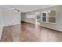 Bright living room featuring hardwood floors, a ceiling fan, and a view into the kitchen at 389 S Kalispell Way # C, Aurora, CO 80017