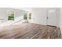 Open living space featuring laminate flooring, white walls, and natural light from dual windows at 1636 Geneva St, Aurora, CO 80010
