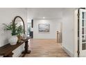 Bright entryway showcasing hardwood floors, stylish console table with decor, and a glimpse into the home's layout at 4 Doral Ln, Littleton, CO 80123