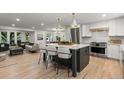Open-concept living room with kitchen island, stainless appliances, and comfortable seating, ideal for entertaining at 4 Doral Ln, Littleton, CO 80123