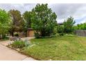 Inviting two-story home with a green lawn and mature trees adding curb appeal at 18206 E Loyola Dr, Aurora, CO 80013