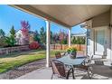 Covered patio with seating area overlooking a fenced backyard at 678 Kryptonite Dr, Castle Rock, CO 80108