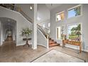 Bright foyer with high ceilings, a grand staircase, and elegant decor at 1425 Autumnwood Ln, Evergreen, CO 80439