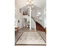 Grand foyer with high ceilings, tile flooring, and a curved staircase with wood treads at 1425 Autumnwood Ln, Evergreen, CO 80439