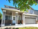 Inviting two-story home with a covered porch, brick accents, and an attached two-car garage at 3554 S Jebel Cir, Aurora, CO 80013