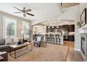 Spacious living room flows into an open kitchen with breakfast bar and modern appliances at 9528 Pendio Ct, Highlands Ranch, CO 80126