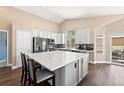 Spacious kitchen with a large center island, white countertops, stainless steel appliances, and ample cabinet space at 2209 Lupine Pl, Erie, CO 80516