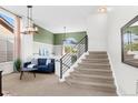 Bright living room featuring high ceilings, modern staircase, and stylish decor at 8864 S Field Ct, Littleton, CO 80128