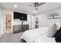 Cozy main bedroom featuring a large TV, ceiling fan, and access to an en-suite bathroom at 7488 S Lafayette E Cir, Centennial, CO 80122