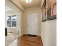 Inviting entryway with hardwood floors, neutral paint, and view into living room with ample natural light at 2033 E 167Th Way, Thornton, CO 80602