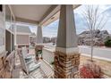 Inviting front porch with rocking chairs and stone pillars, perfect for relaxing outdoors at 2033 E 167Th Way, Thornton, CO 80602