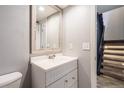 Bathroom with white vanity, modern fixtures, and a decorative mirror and adjacent to the stairway at 2314 S Troy St, Aurora, CO 80014