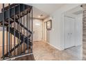 Foyer featuring a staircase with dark railings and herringbone-patterned tile flooring at 2314 S Troy St, Aurora, CO 80014