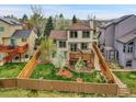 Aerial view of the backyard featuring a spacious lawn, privacy fence, and a wooden deck at 6343 Laguna Cir, Highlands Ranch, CO 80130