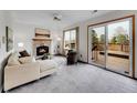 Cozy living room boasts a fireplace, plush seating, and sliding doors to the outdoor deck at 6343 Laguna Cir, Highlands Ranch, CO 80130