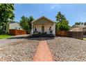 Quaint home featuring low-maintenance landscaping and a cozy covered front porch at 4450 S Fox St, Englewood, CO 80110
