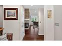 Hallway with view into the living area with fireplace and dark hardwood floors and neutral walls at 11208 W Ontario Ave, Littleton, CO 80127