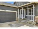 Entryway showcasing the front door, garage, and small, covered porch at 261 Hermosa St, Brighton, CO 80603