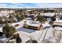 Aerial view of home with fenced backyard, mature trees, and snow-covered ground at 6834 Hillside Way, Parker, CO 80134