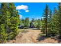 Exterior of home surrounded by dense trees and a wide, natural landscape at 10411 Dowdle Dr, Golden, CO 80403