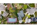 An aerial view showcasing the property's backyard, including a tennis court and lush landscaping at 2500 Van Gordon St, Lakewood, CO 80215