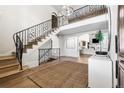 Bright foyer with an arched entryway and an ornamental iron staircase to the second floor at 2500 Van Gordon St, Lakewood, CO 80215