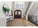Bright foyer featuring a decorative wrought iron staircase and arched wooden front doors at 2500 Van Gordon St, Lakewood, CO 80215