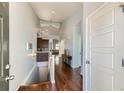 Inviting entryway with hardwood floors leading to a modern kitchen and staircase at 5181 Delphinium Cir, Brighton, CO 80601