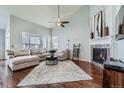 Cozy living room with a fireplace, hardwood floors, large window and comfortable seating at 5181 Delphinium Cir, Brighton, CO 80601