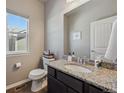Stylish powder room featuring granite countertop vanity, decorative mirror, and modern fixtures, adding elegance at 2431 Nicholson St, Berthoud, CO 80513