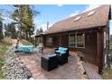A stunning stone patio features comfortable seating areas for outdoor relaxation and entertaining at 11724 Little Turtle Ln, Conifer, CO 80433