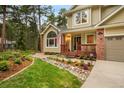 Charming home featuring a landscaped yard, a covered front porch, and brick accents adding to the curb appeal at 10 Long Bow Cir, Monument, CO 80132
