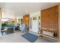 Inviting covered front porch featuring brick accents and comfortable seating at 7970 S Cook Way, Centennial, CO 80122