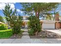 Well-maintained home featuring a front yard with mature trees and attached garage at 7970 S Cook Way, Centennial, CO 80122