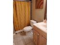 Cozy bathroom featuring decorative tile work, a warm vanity, and unique gold shower curtain at 1755 S Pitkin St # B, Aurora, CO 80017
