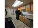 Efficient kitchen featuring stainless steel appliances, tile floors, and a bright skylight at 1755 S Pitkin St # B, Aurora, CO 80017