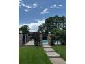 Community pool behind a decorative wrought iron fence, under a sunny sky with mature trees at 1755 S Pitkin St # B, Aurora, CO 80017