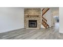 Living room featuring a stone fireplace and hardwood stairs at 11973 E Kepner Dr, Aurora, CO 80012