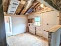 Unfinished kitchen space ready for customization, featuring exposed studs and a new window at 6608 Hooker St, Denver, CO 80221