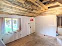 Living room featuring original hardwood floors, new windows and a rustic ceiling at 6608 Hooker St, Denver, CO 80221