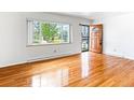 Bright living room boasts hardwood floors, a large window with neighborhood views, and a stylish front door at 12022 W Louisiana Ave, Lakewood, CO 80228