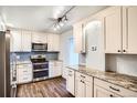 Updated kitchen features stainless appliances, modern cabinetry, stone counters, and stylish tile backsplash at 3131 E Alameda Ave # 1503, Denver, CO 80209