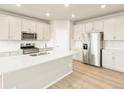 This kitchen features stainless steel appliances, an island, and sleek, white cabinetry at 24088 E Atlantic Pl, Aurora, CO 80018