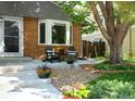 Inviting front porch with brick accents, lounge furniture, decorative planters and appealing landscaping at 7869 S Valentia St, Centennial, CO 80112