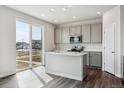 Modern kitchen featuring an island, stainless steel appliances, and sliding glass doors to the outside at 14378 Heritage Dr, Mead, CO 80504