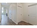 Hallway with wood floors, multiple doors, and white walls provide a clean and bright transition between rooms at 13457 Valentia St, Thornton, CO 80602
