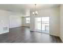 Spacious living room with wood flooring, large windows, and a sliding glass door leading to the outdoor patio at 13457 Valentia St, Thornton, CO 80602