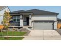 New single-story home with gray siding, stone accents and a two-car garage at 17305 E 91St Pl, Commerce City, CO 80022