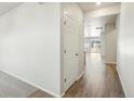 Hallway with hardwood floors and white walls, leading to other rooms in the home at 17305 E 91St Pl, Commerce City, CO 80022