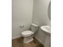 Clean powder room features modern fixtures, new toilet, and pedestal sink at 21965 E 39Th Ave, Aurora, CO 80019